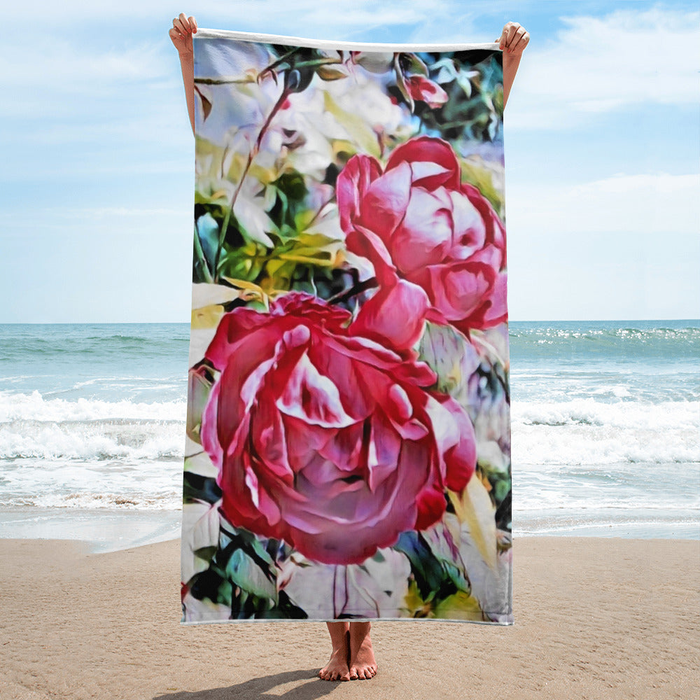 a pink rose in a vase on a beach