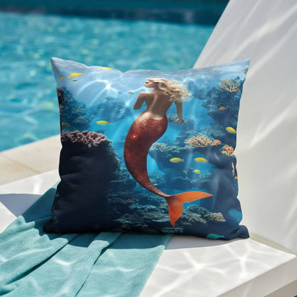 All-Over Print Basic Pillow placed on a poolside chair, featuring the Mermaid design with a swimming mermaid, coral reefs, vibrant fish, and deep blue underwater tones. The scene highlights the aquatic theme in bright natural light.