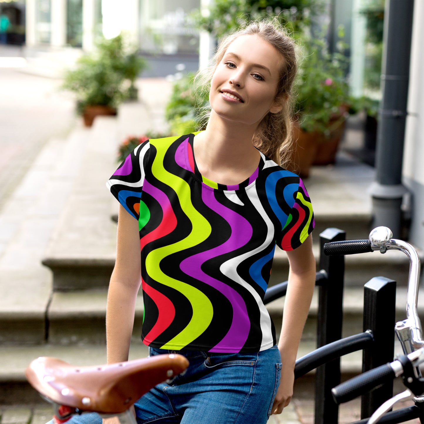 All-Over Print Crop Tee – Vibrant Echoes design inspired by retro 60s abstract art. Colorful wavy lines in purple, green, red, and yellow. Vintage-modern artistic crop tee for women, bold and stylish summer fashion piece.