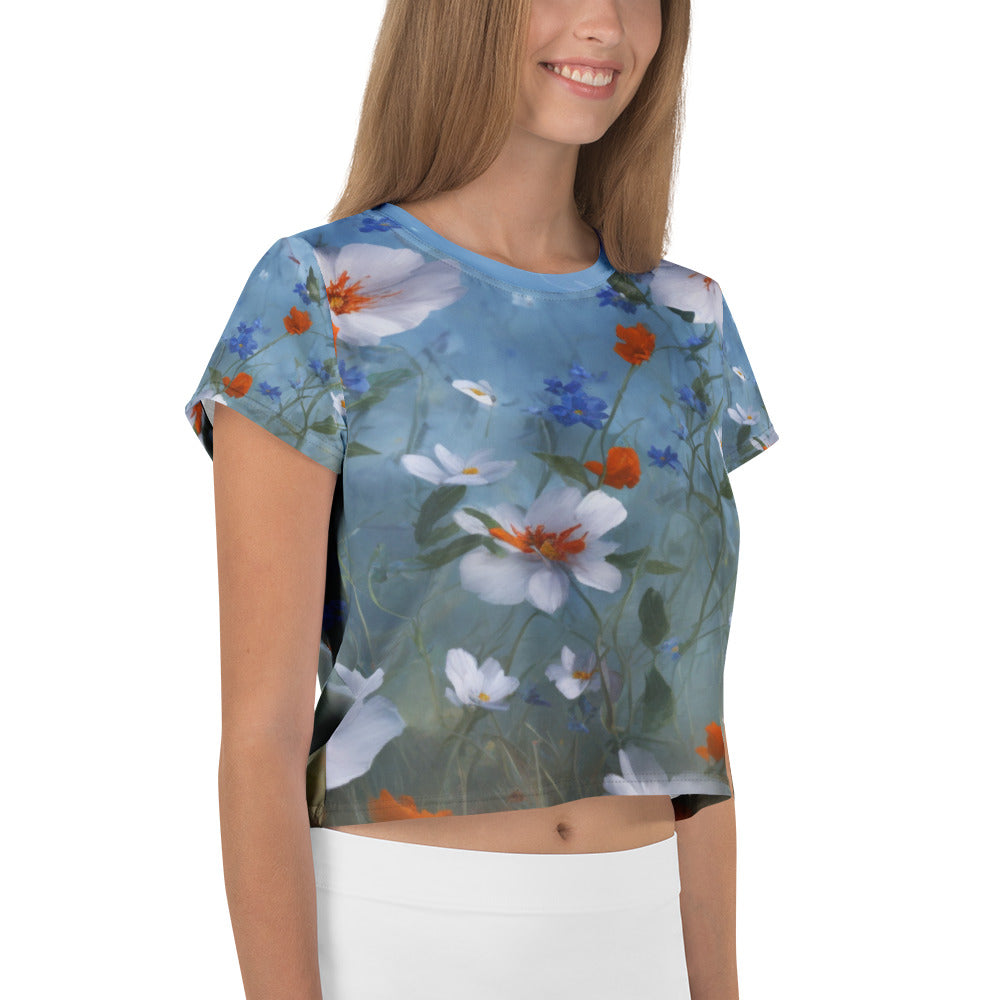 All-Over Print Crop Tee with vintage floral art naïf design featuring white, orange, and blue flowers under a poetic storm – artistic women’s top blending elegance and emotion.