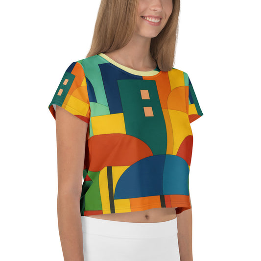 All-over print crop tee featuring the Vintage Naive Abstract Cityscape design in bright geometric colors inspired by mid-century naïve art, showing rooftops and umbrellas that express joy, creativity, and artistic optimism.