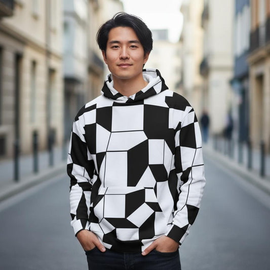 black and white geometric facettes pattern hoodie worn by a young man standing in a bright urban street modern sixties inspired design with bold shapes and clean lines detailed fabric texture visible on sleeves and hood all over print unisex hoodie shown clearly for product presentation