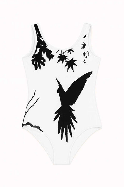 Kids swimsuit with black parrot silhouette on white background, artistic nature design showing leaves and branches, minimalist bird illustration flat lay on neutral surface