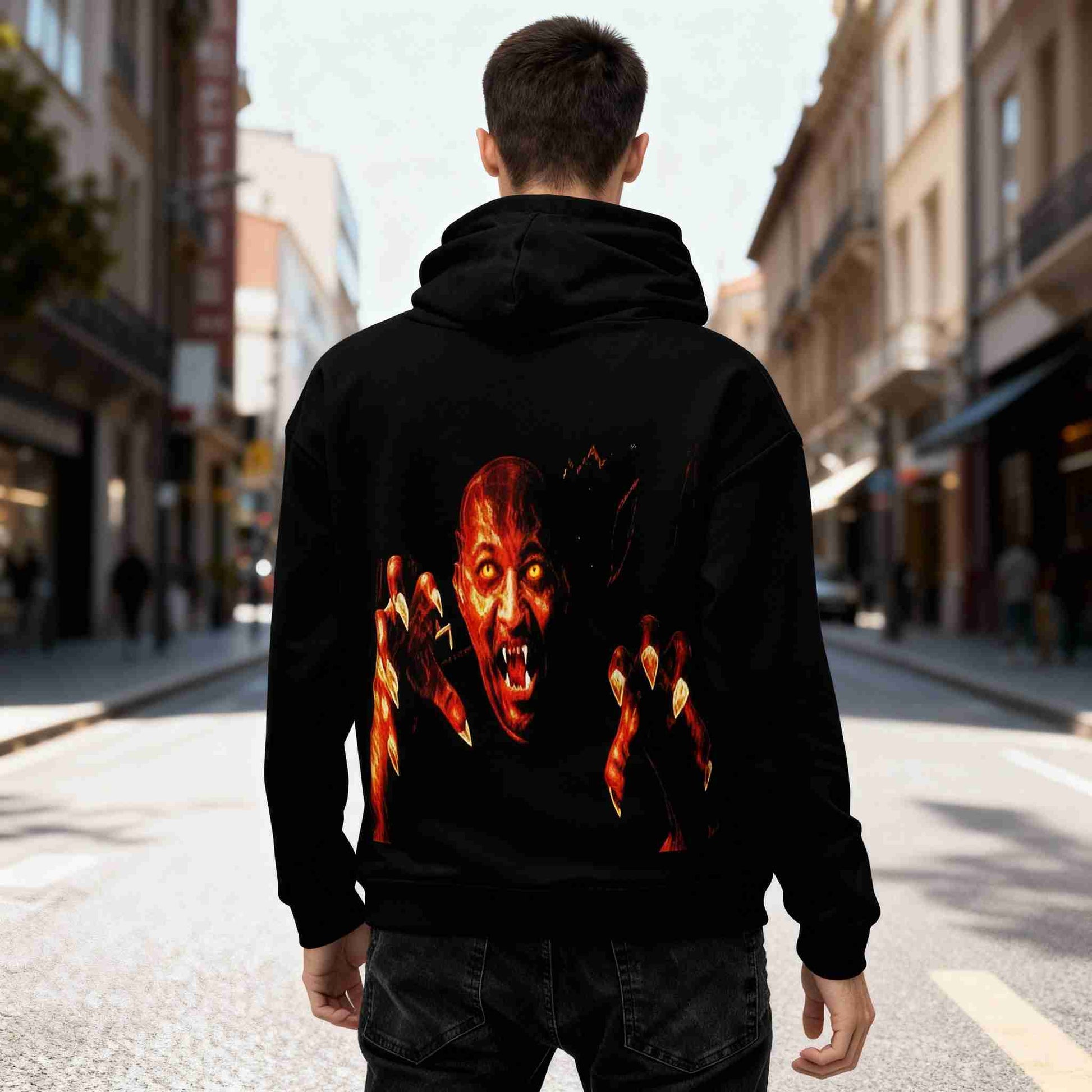 realistic scene of a black all-over print recycled unisex hoodie in a bright urban street, showing a fiery vampiric face with glowing yellow eyes and extended burning claws printed large on the back, vivid colors, detailed shadows and fabric texture