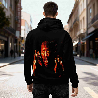 realistic scene of a black all-over print recycled unisex hoodie in a bright urban street, showing a fiery vampiric face with glowing yellow eyes and extended burning claws printed large on the back, vivid colors, detailed shadows and fabric texture