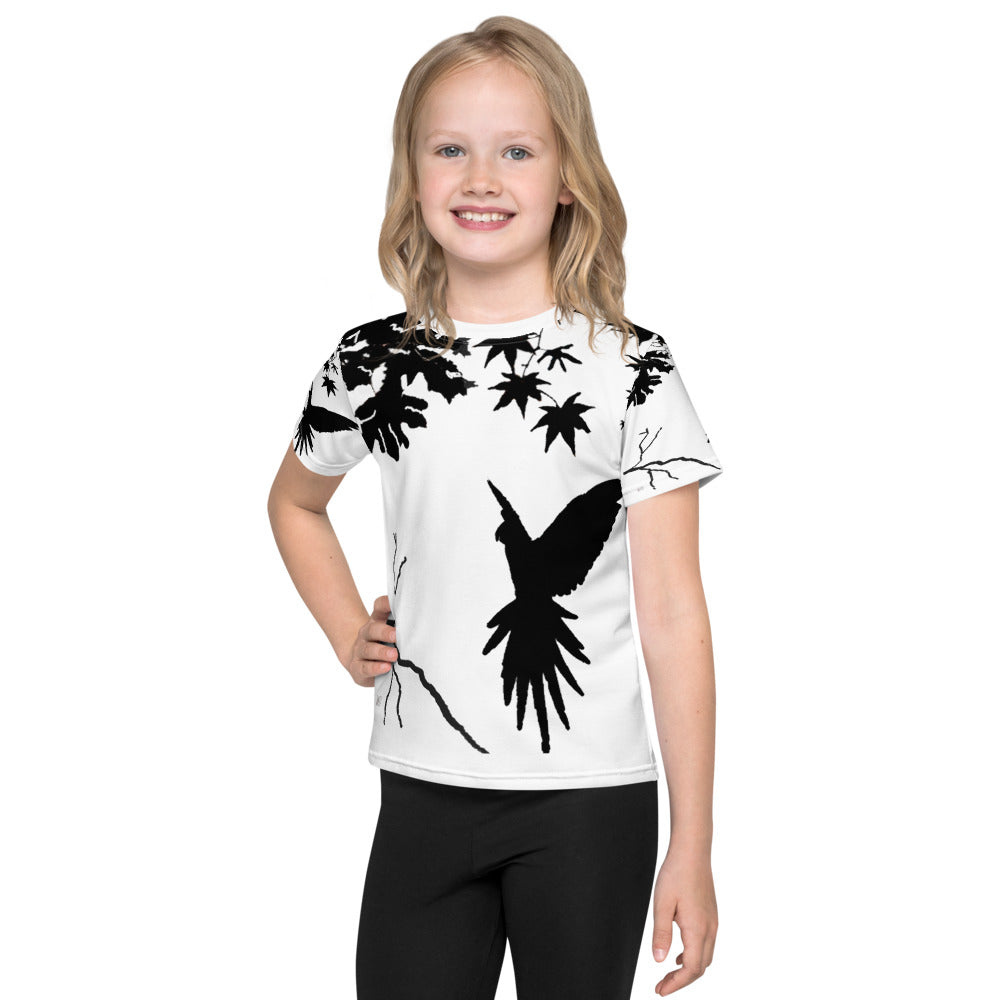 Smiling child wearing a Kids T-Shirt with Freedom design featuring a parrot bird silhouette landing on a branch, black on a light background, artistic minimalist style inspired by nature and freedom.