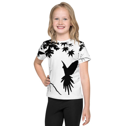 Smiling child wearing a Kids T-Shirt with Freedom design featuring a parrot bird silhouette landing on a branch, black on a light background, artistic minimalist style inspired by nature and freedom.